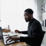 Public Interest Score Calculators in South Africa: Common Mistakes and How to Avoid Them Professional using a laptop while reviewing information related to a Public Interest Score Calculator South Africa