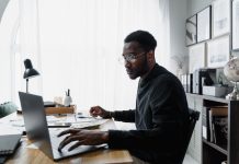 Public Interest Score Calculators in South Africa: Common Mistakes and How to Avoid Them Professional using a laptop while reviewing information related to a Public Interest Score Calculator South Africa