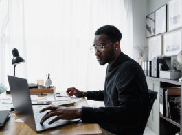 Public Interest Score Calculators in South Africa: Common Mistakes and How to Avoid Them Professional using a laptop while reviewing information related to a Public Interest Score Calculator South Africa