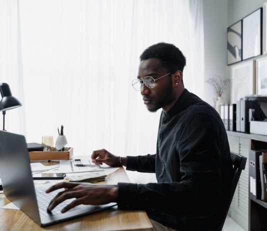 Public Interest Score Calculators in South Africa: Common Mistakes and How to Avoid Them Professional using a laptop while reviewing information related to a Public Interest Score Calculator South Africa